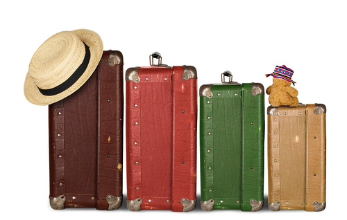 Family Travel / ©yamix - stock.adobe.com, yamix - stock.adobe.com Four Suitcases with Summer Hat and Cuddly Bunny